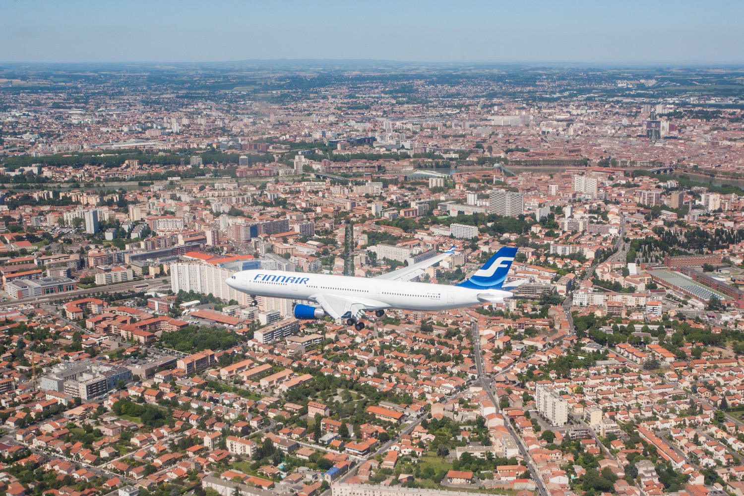 Prise de vue aérienne d'une Airbus A330 devant la ville de Toulouse en arrière plan