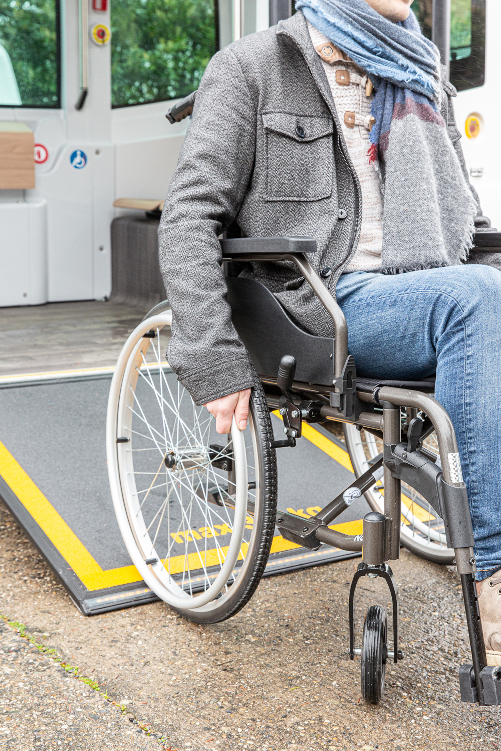 Une personne en fauteuil roulant utilise la rampe pour accéder au véhicule Easymile ES10