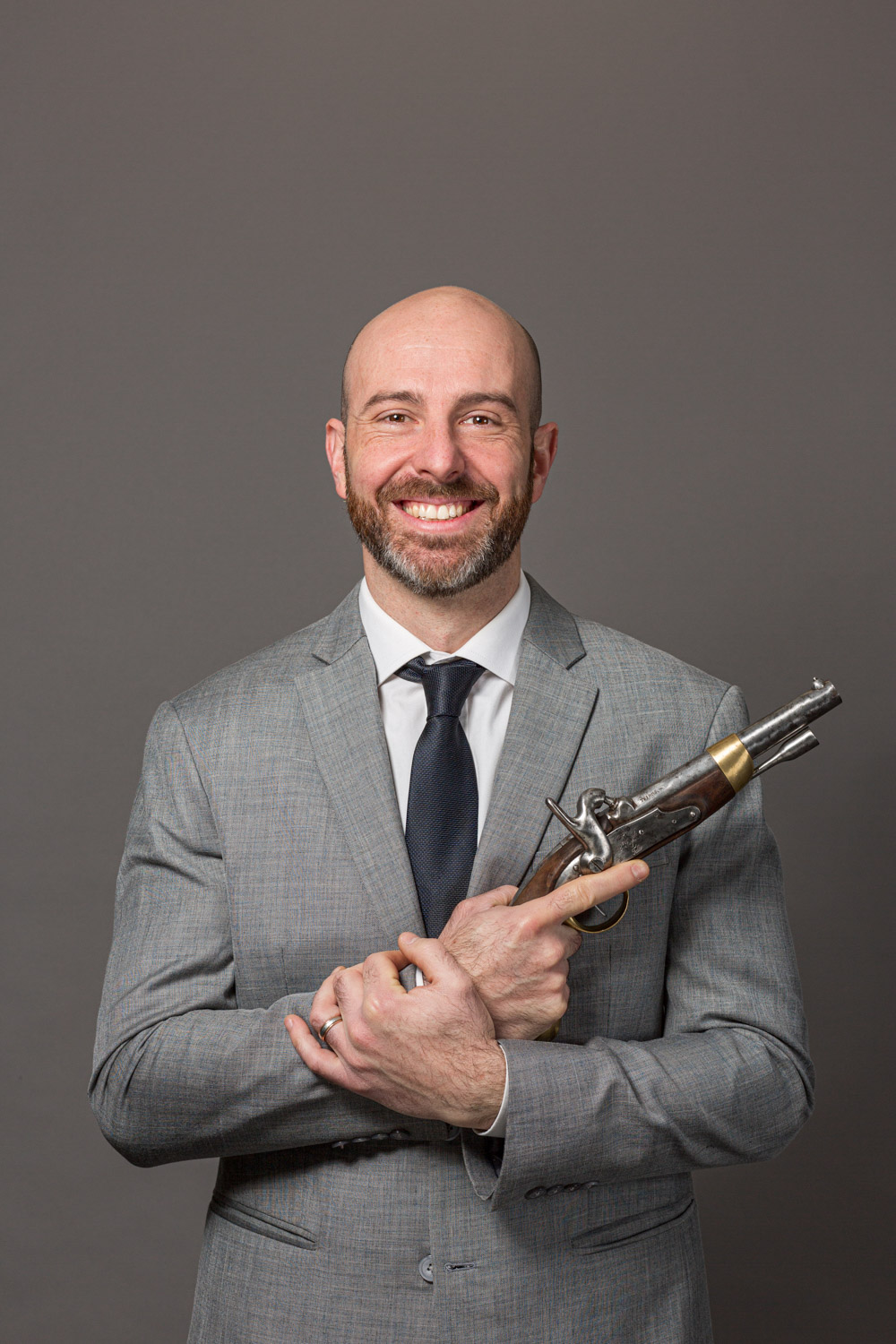 Un associés d'entreprise porte un ancien pistolet dans les mains pour une photographie portrait corporate